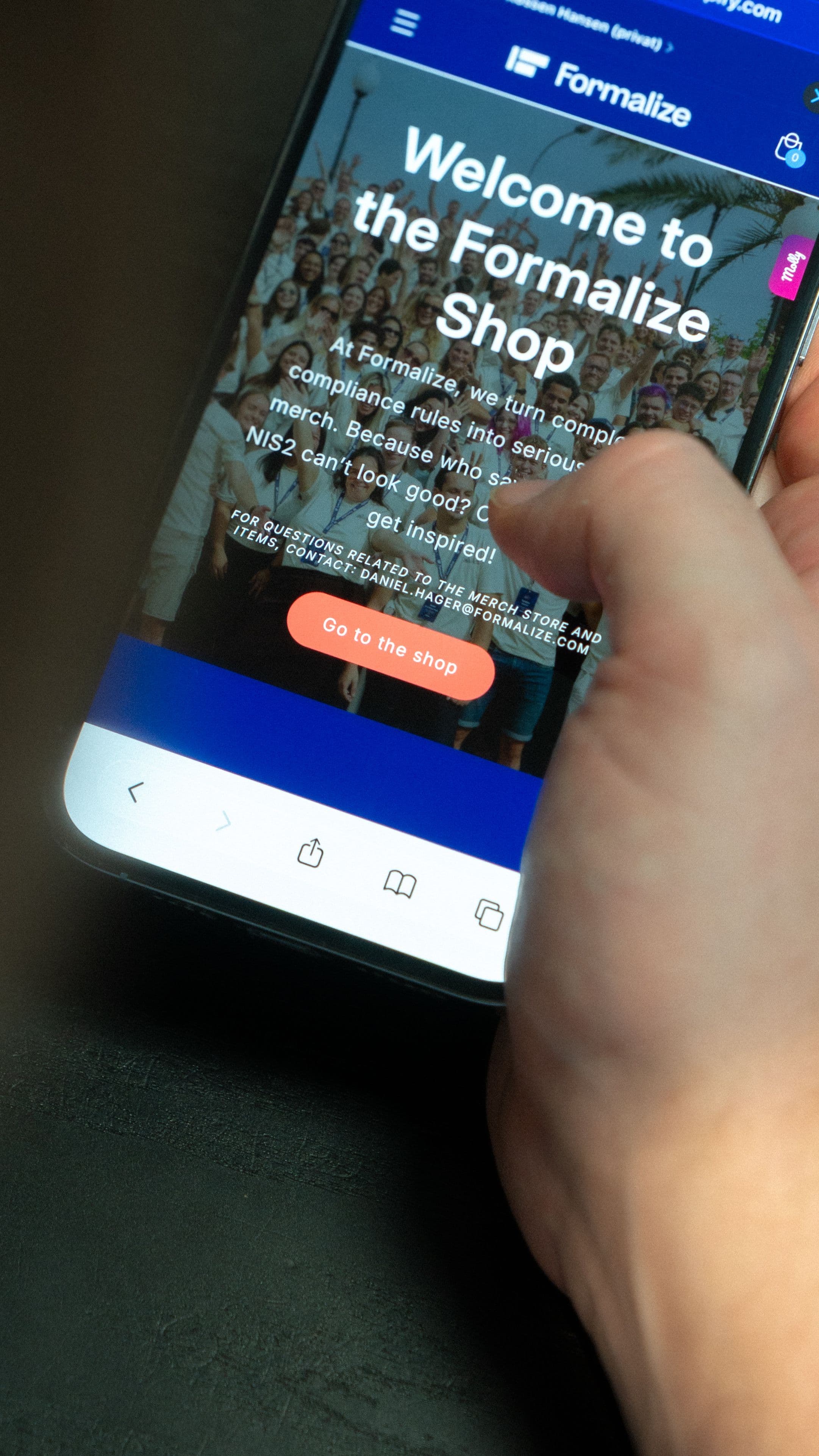 A hand holds a smartphone displaying the Formalize Shop webpage, showing a crowd of people and a "Go to the shop" button.