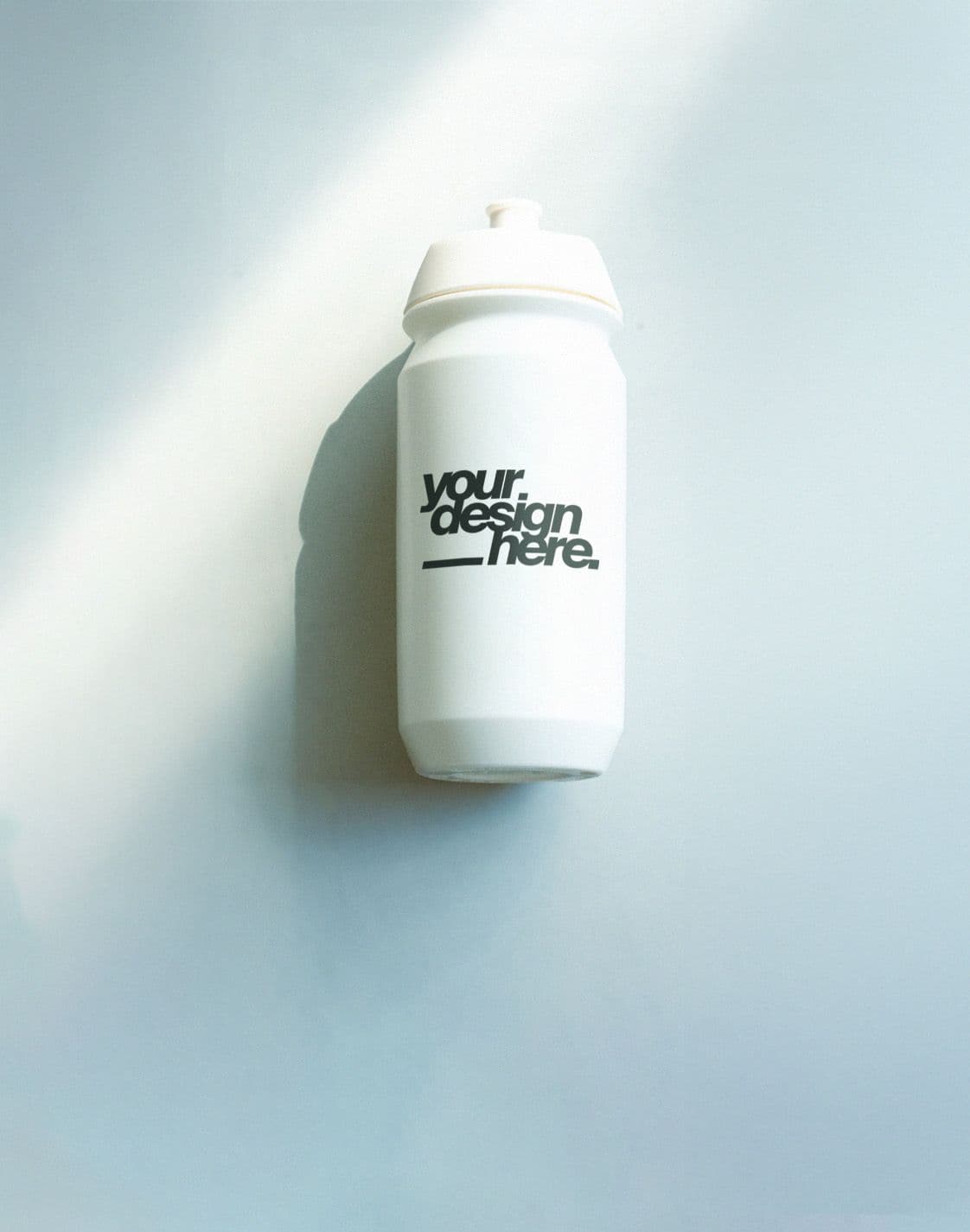 White water bottle with "your design here" text on a light blue background with a sunbeam.